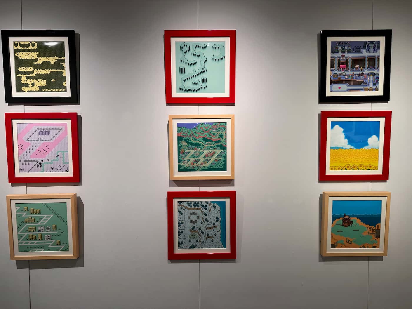 Framed maps from Mother 1, 2, and 3 displayed on the wall at the Mother Museum exhibition.