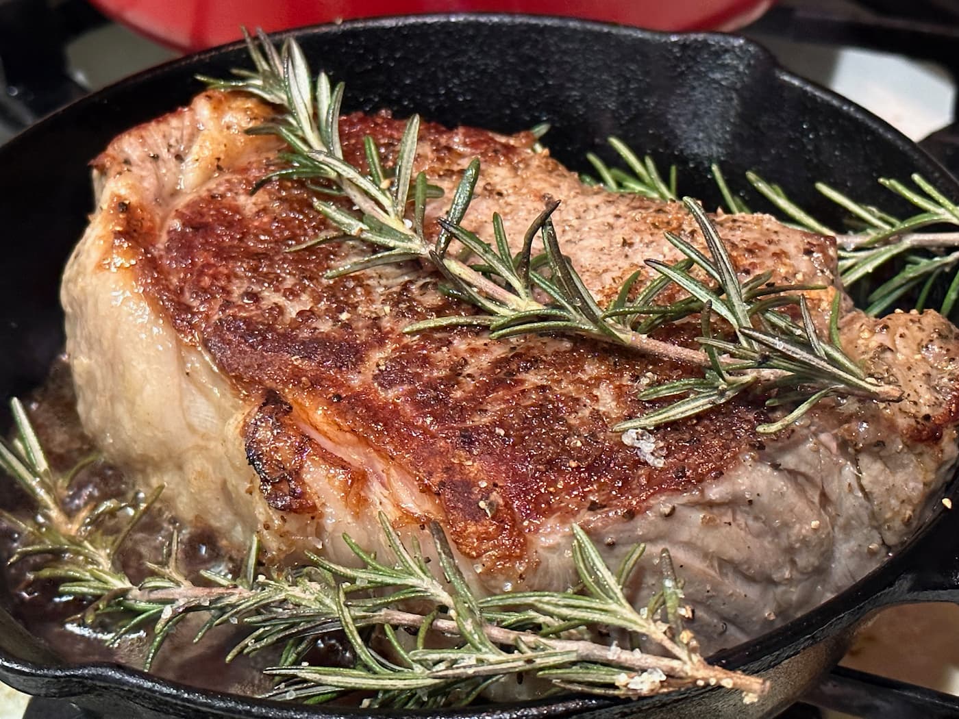 Beautiful steak searing inside a skillet after being cooked using the sous vide method.